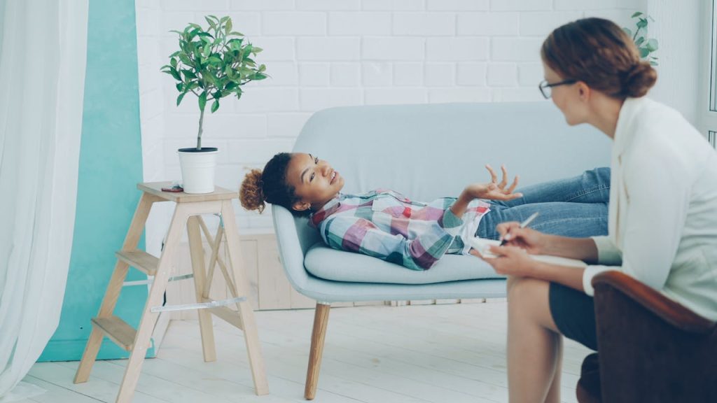 Cozy therapy office with client and therapist during a session.